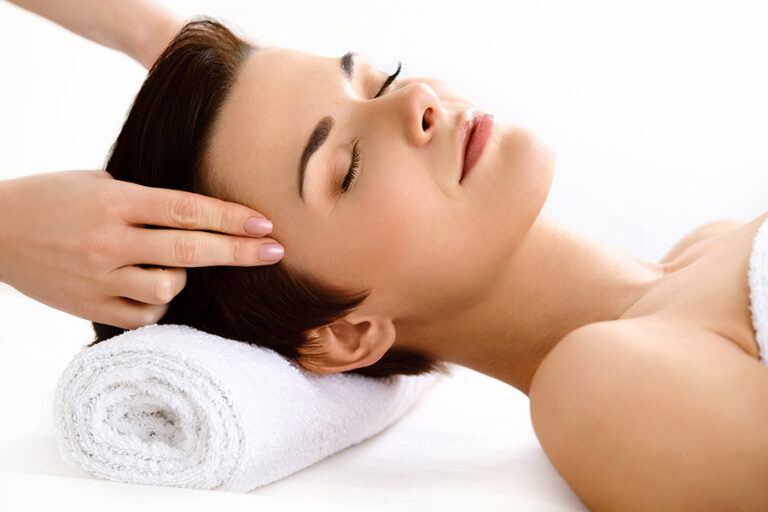 Face Massage. Beautiful Woman Getting Treatment In Spa Clinic
