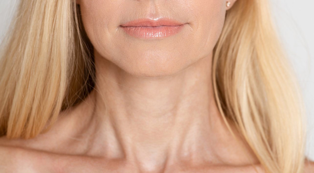 Close-Up Of The Lower Face And Neck Of A Middle-Aged Woman With Smooth Skin And Light Blonde Hair.